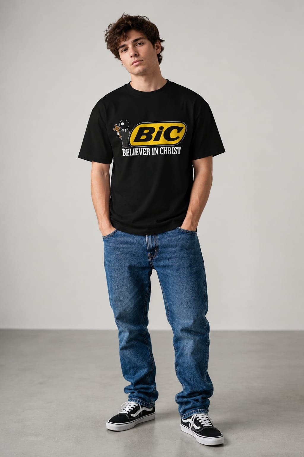 Model wearing the black Believer In Christ T-Shirt with jeans in a studio